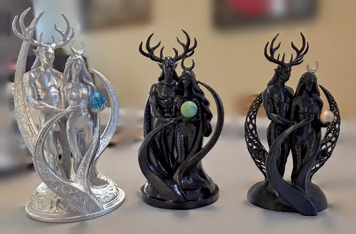 Three Held Light sculptures side by side, one silver and two black, 3D printed by Foolish Form.